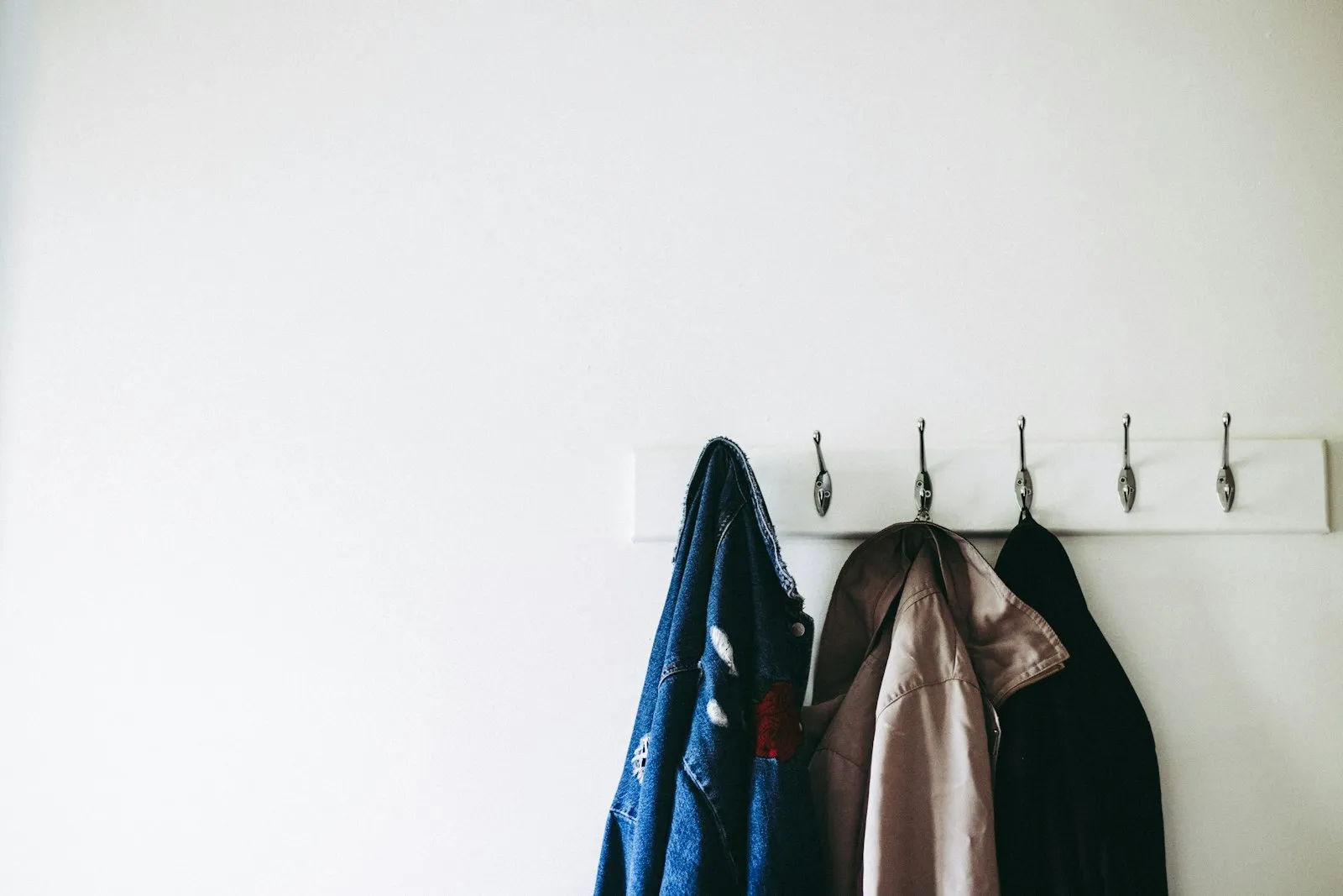 Warm coats hanging on wall hooks by a door